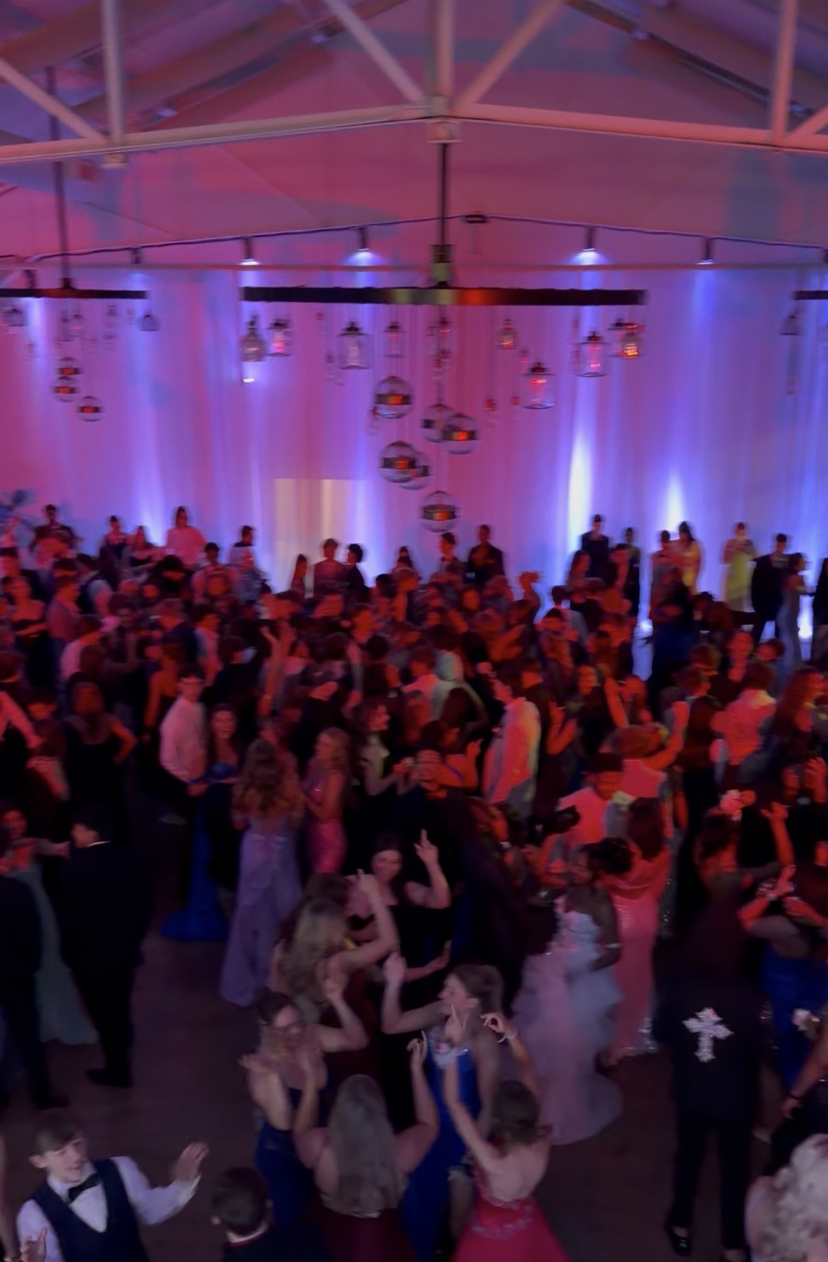 Packed prom dance floor with uplighting and disco balls